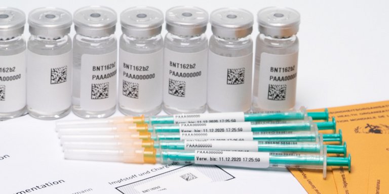 Impfpass mit Impfflüssigkeit und Spritzen