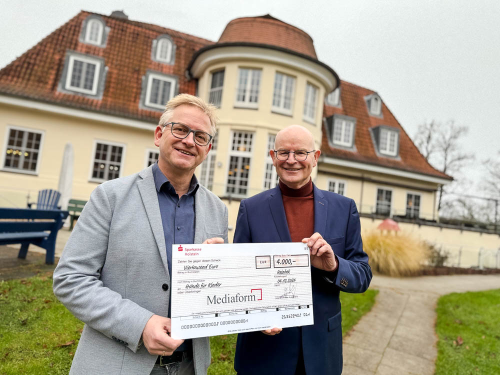 Jörg Weber (Mediaform) und Steffen Schumann ("Hände für Kinder") mit dem Spendenscheck